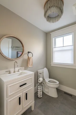 a bathroom with a toilet a sink and mirror