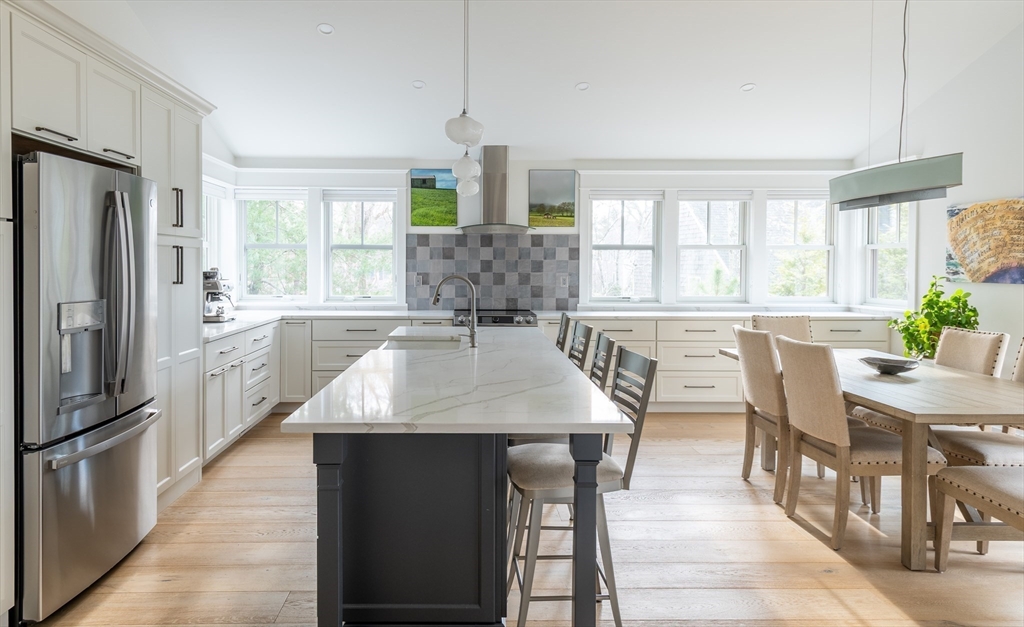 75 Streeter Hill Road Falmouth, MA 02556 - Photo 10 of 32 a large kitchen with stainless steel appliances granite countertop a table chairs refrigerator and a window