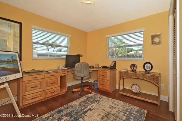 a view of a workspace with furniture and a window