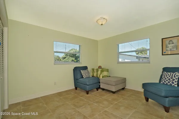 a living room with couches and a potted plant