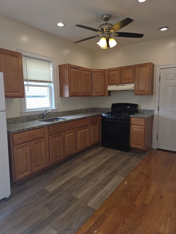 92 Lucerne Street, Unit 2 Boston, MA 02124 - Photo 1 of 7 a kitchen with stainless steel appliances granite countertop a sink dishwasher stove and cabinets with wooden floor