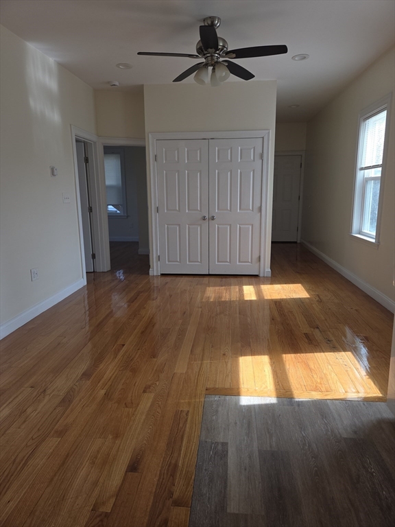 92 Lucerne Street, Unit 2 Boston, MA 02124 - Photo 3 of 7 an empty room with wooden floor closet and windows