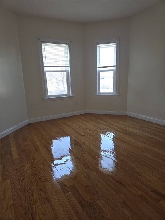 92 Lucerne Street, Unit 2 Boston, MA 02124 - Photo 4 of 7 a room with wooden floor and window
