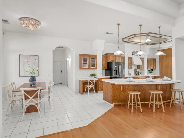a living room with couches a flat screen tv and view of kitchen