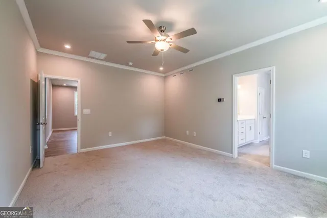 an empty room with closet and a ceiling fan