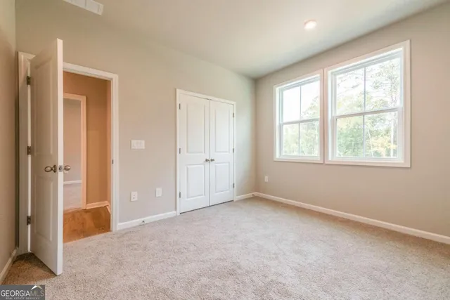 an empty room with windows and closet