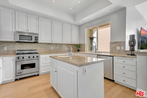 a bathroom with a granite countertop sink a mirror and shower