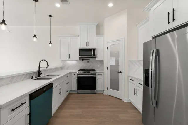 a kitchen with appliances a sink and cabinets