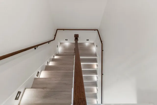 a view of a hallway with wooden floor and staircase