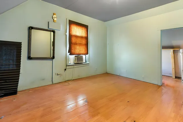 a view of an empty room with window and bathroom