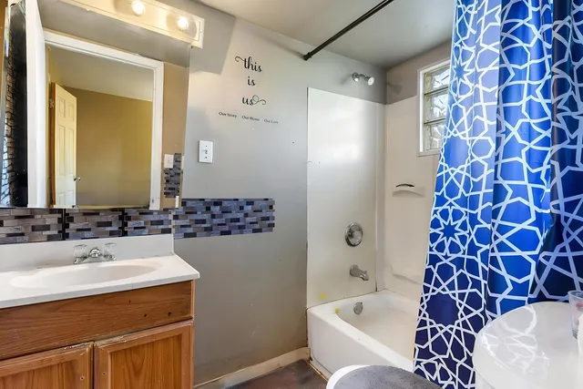 a bathroom with a bathtub sink mirror and toilet