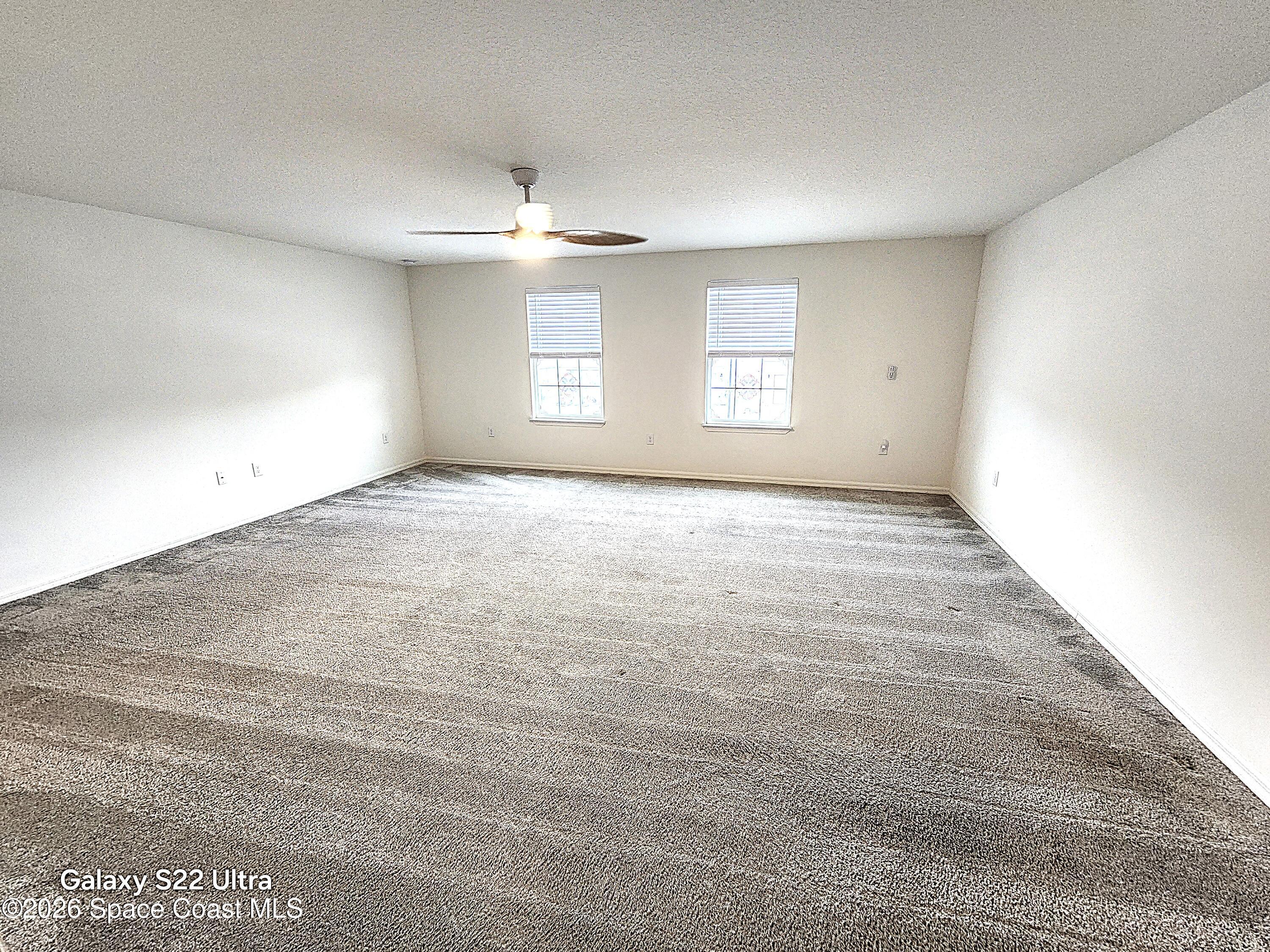1043 Corbin Circle Southwest Palm Bay, FL 32908 - Photo 11 of 18 an empty room with windows and ceiling fan