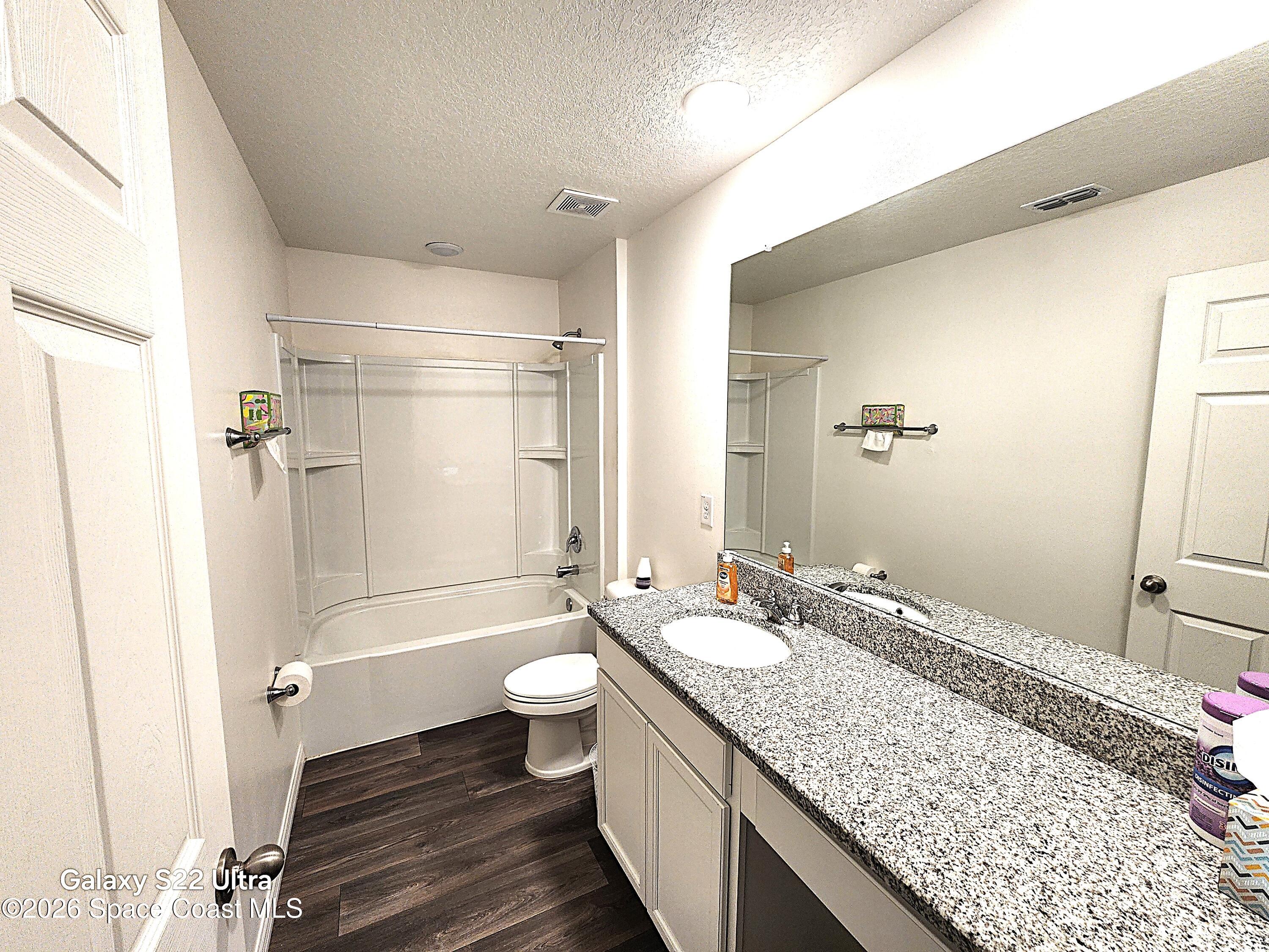 1043 Corbin Circle Southwest Palm Bay, FL 32908 - Photo 18 of 18 a bathroom with a granite countertop sink toilet and shower