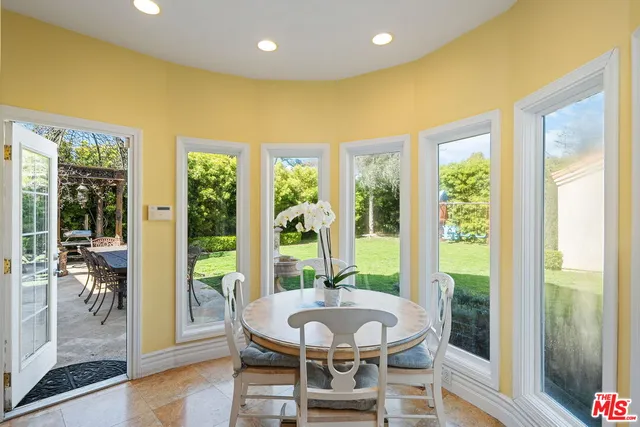 a view of a dining room with furniture large windows and wooden floor