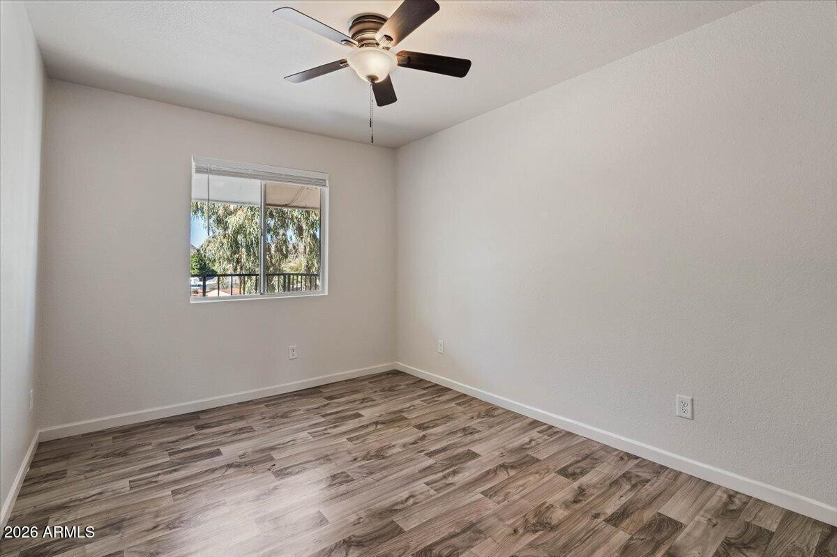 1346 East Mountain View Road, Unit 207 Phoenix, AZ 85020 - Photo 24 of 31 a view of an empty room with a window and wooden floor