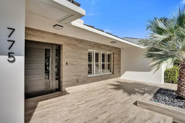 a kitchen with stainless steel appliances granite countertop a stove a refrigerator a microwave oven a dining table and chairs with wooden floor