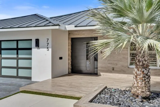 a large kitchen with granite countertop a large counter top a sink stainless steel appliances and cabinets