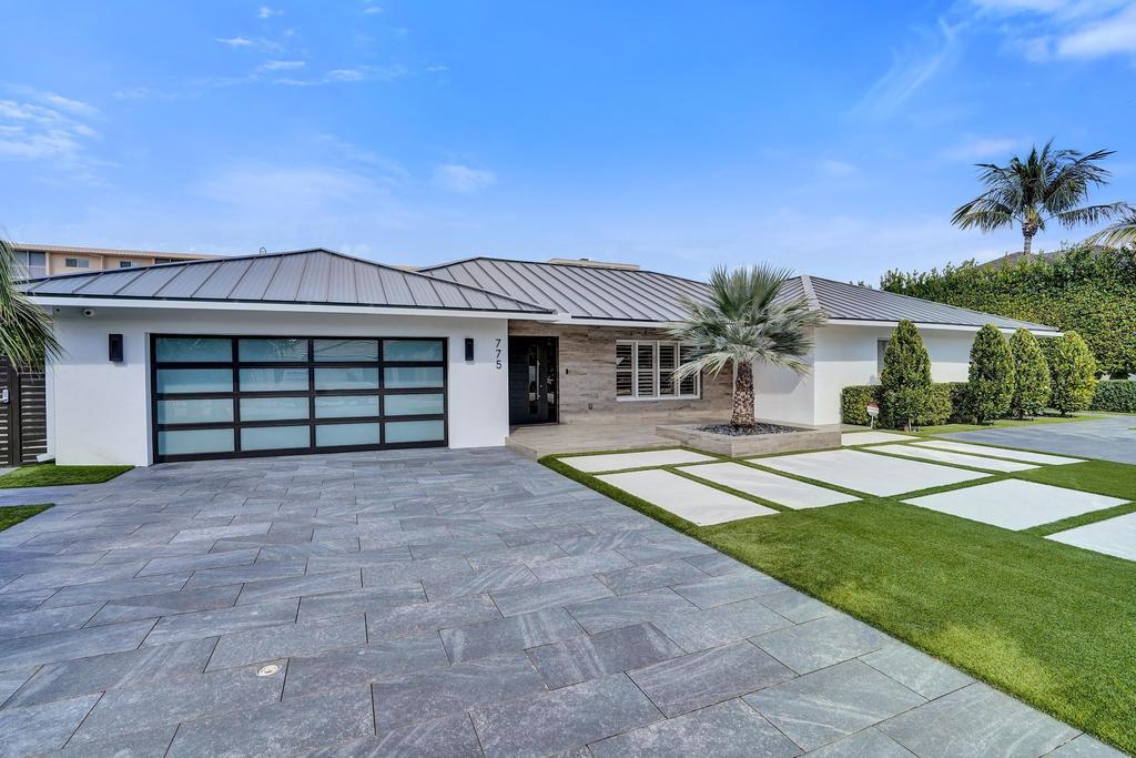 775 Northeast 39th Street Boca Raton, FL 33431 - Photo 16 of 88 a front view of a house with a yard and garage
