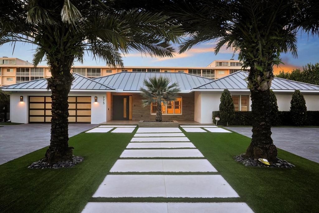775 Northeast 39th Street Boca Raton, FL 33431 - Photo 2 of 88 a front view of a house with a garden and trees