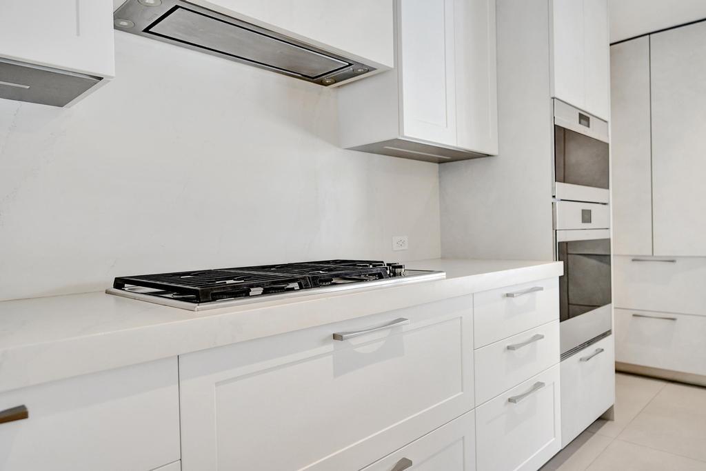 775 Northeast 39th Street Boca Raton, FL 33431 - Photo 26 of 88 a kitchen with white cabinets and white appliances