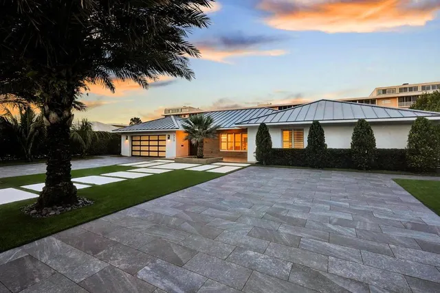 a front view of a house with a yard and trees