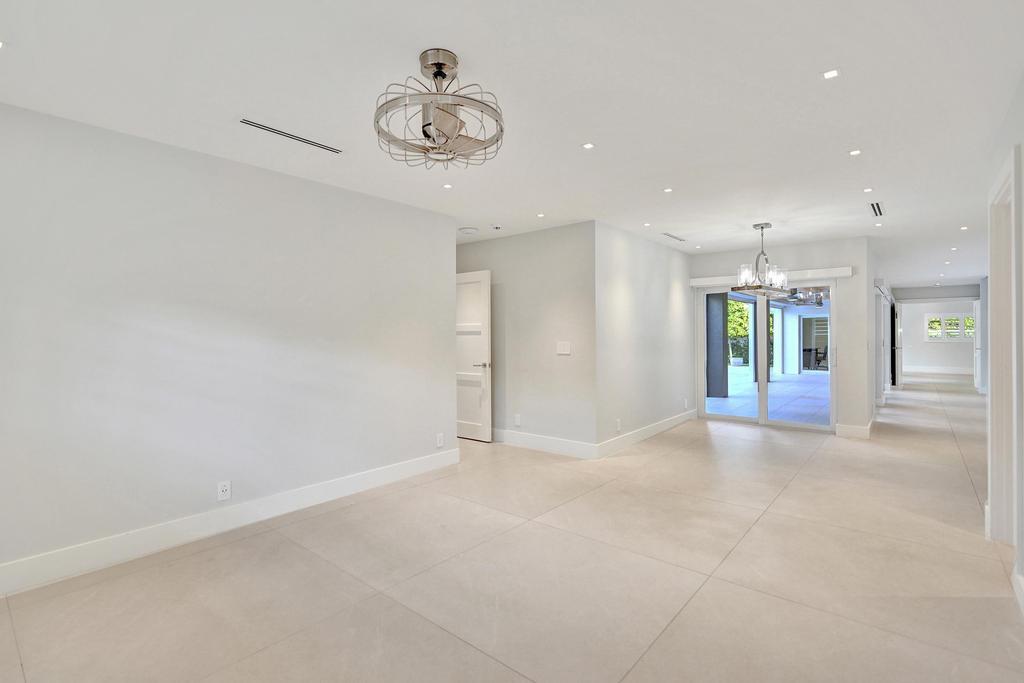 775 Northeast 39th Street Boca Raton, FL 33431 - Photo 50 of 88 an empty room with a chandelier fan and windows