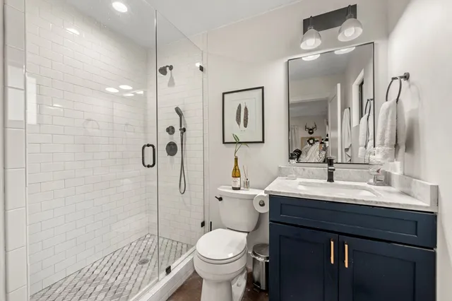 a bathroom with a sink a toilet and shower