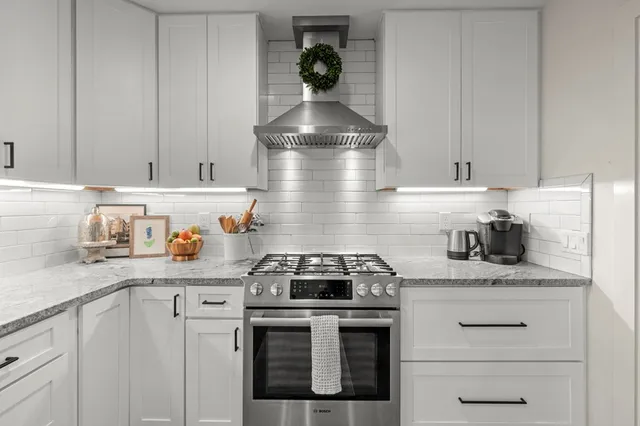 a kitchen with a stove cabinets and granite counter tops