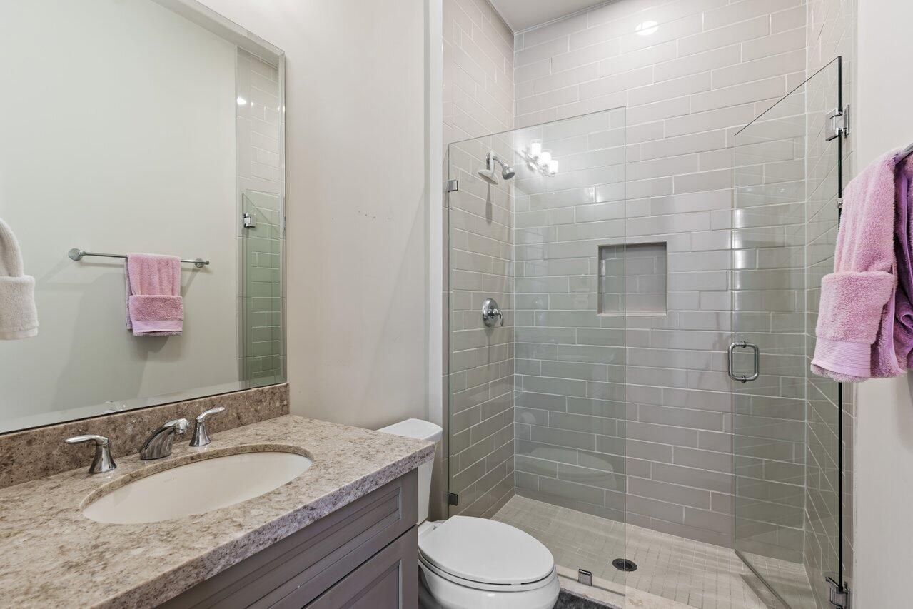 6464 Bellamalfi Street Boca Raton, FL 33496 - Photo 18 of 32 a bathroom with a granite countertop sink toilet a mirror and shower