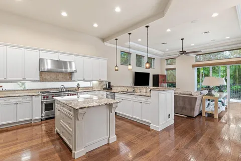 a kitchen with a sink stove cabinets and wooden floor