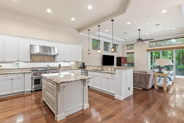 a kitchen with a sink stove cabinets and wooden floor