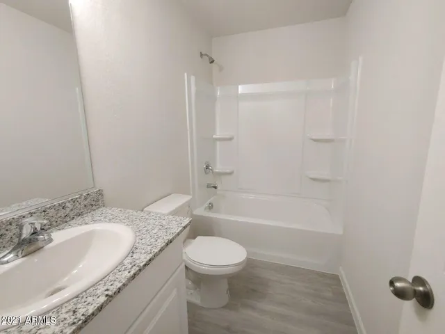 a bathroom with a granite countertop sink a toilet and a bathtub
