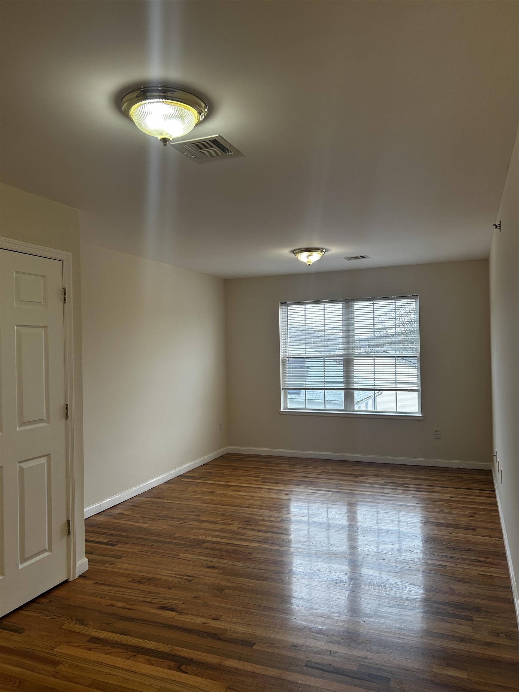 1609 West Lake Avenue, Unit 112 Neptune, NJ 07753 - Photo 3 of 12 a view of an empty room with wooden floor and a window