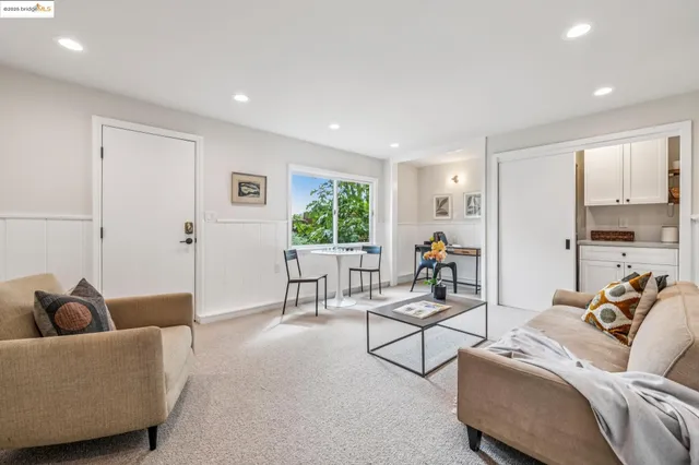 a living room with furniture and a painting on the wall