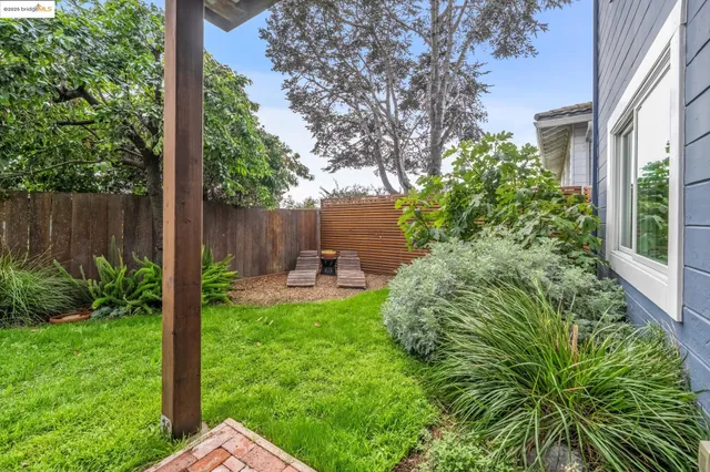 a view of a patio with table and chairs potted plants and wooden fence