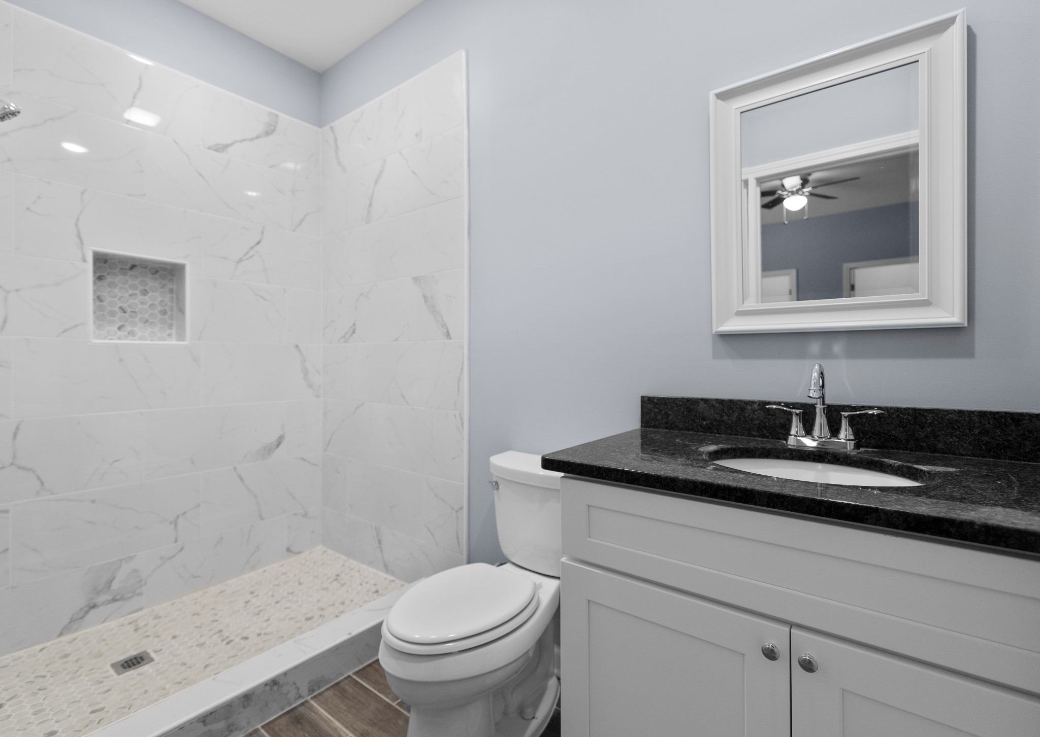 115 Freeman Street, Unit A Tullahoma, TN 37388 - Photo 16 of 25 a bathroom with a granite countertop sink a toilet and a mirror