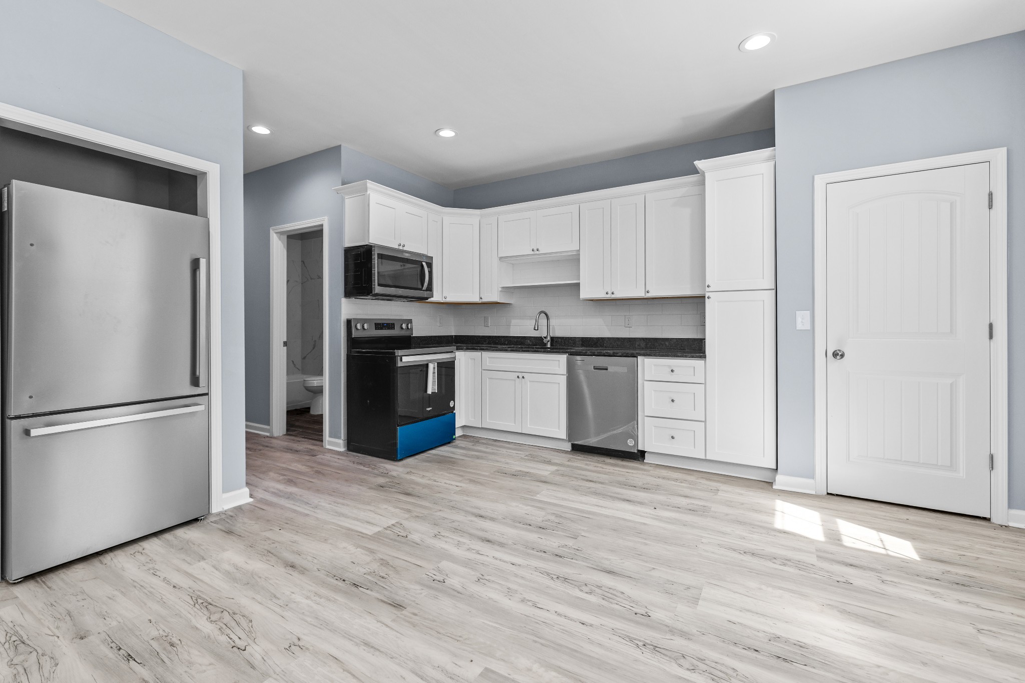 115 Freeman Street, Unit A Tullahoma, TN 37388 - Photo 8 of 25 a kitchen with granite countertop a refrigerator and a stove top oven