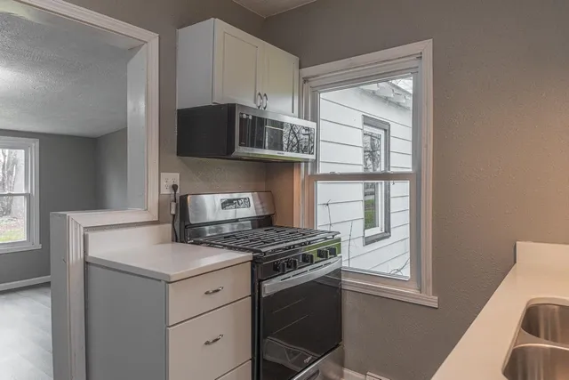 a kitchen with cabinets appliances and a window