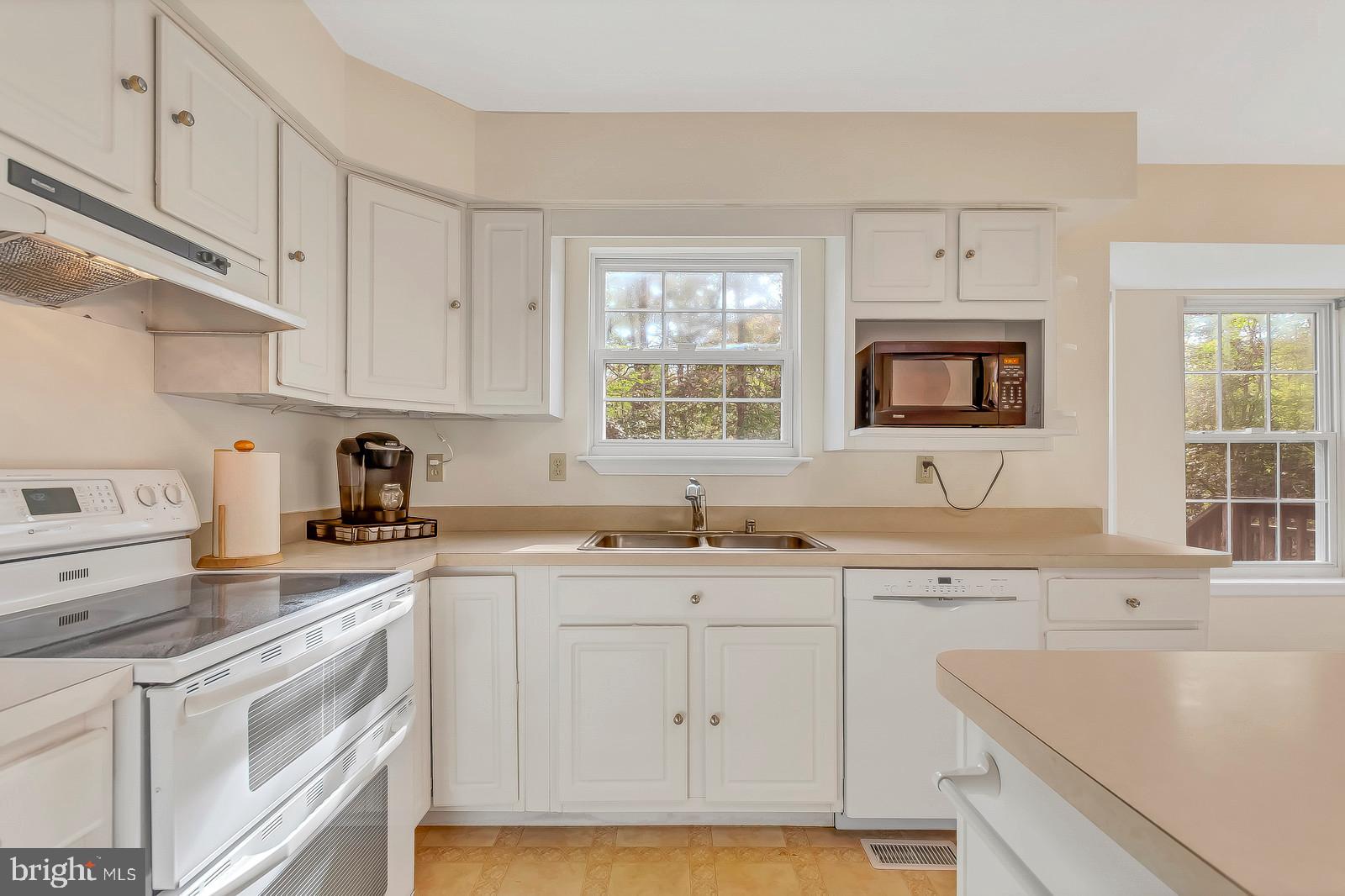 6815 Mackall Road St. Leonard, MD 20685 - Photo 9 of 38 a kitchen with cabinets appliances a sink and a window