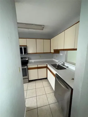 a kitchen with a sink cabinets and a window