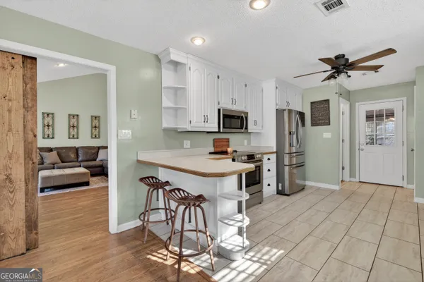 an aerial view of residential houses with outdoor space and trees