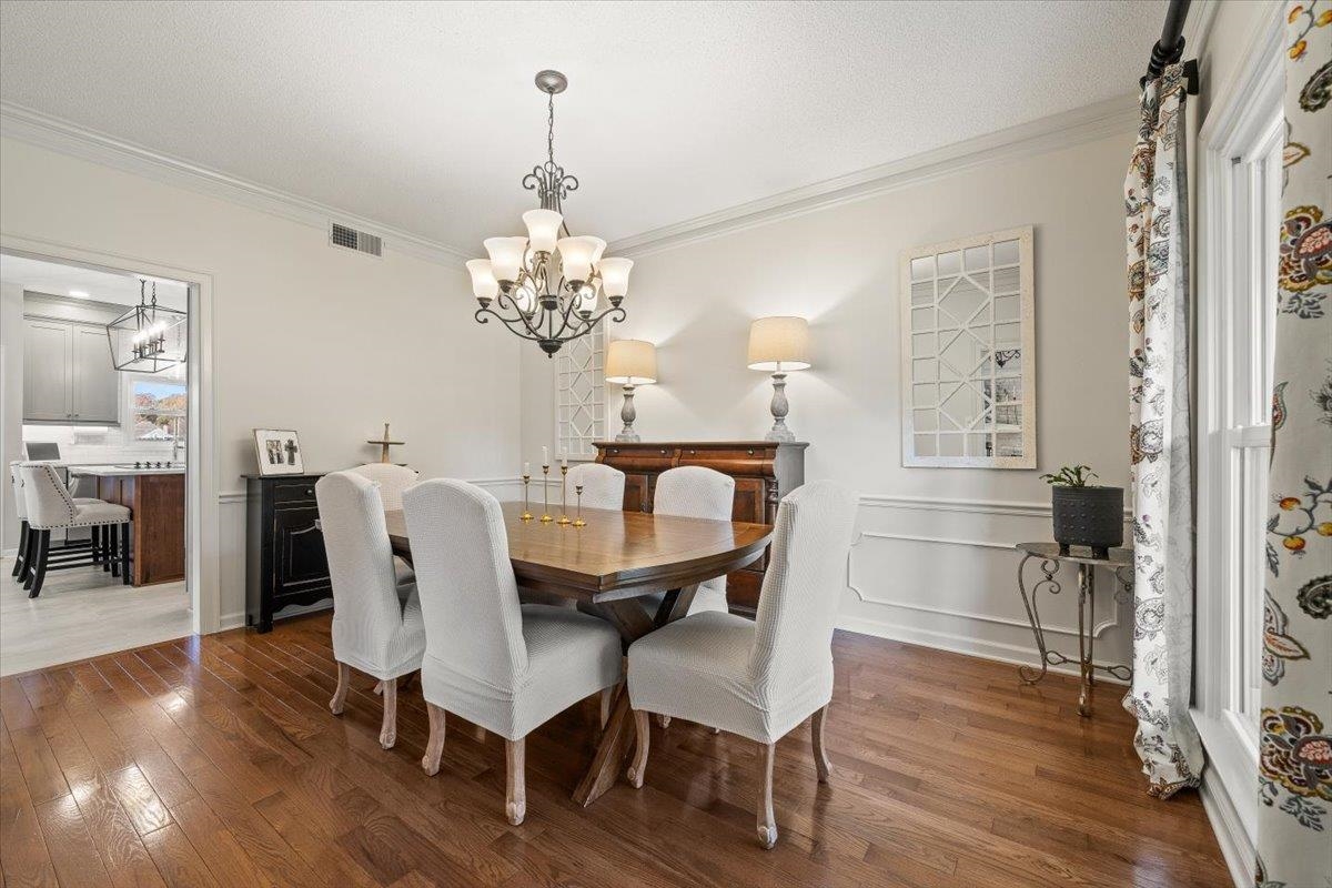 621 Fox Lair Cove Collierville, TN 38017 - Photo 13 of 37 a view of a dining room with furniture wooden floor and chandelier