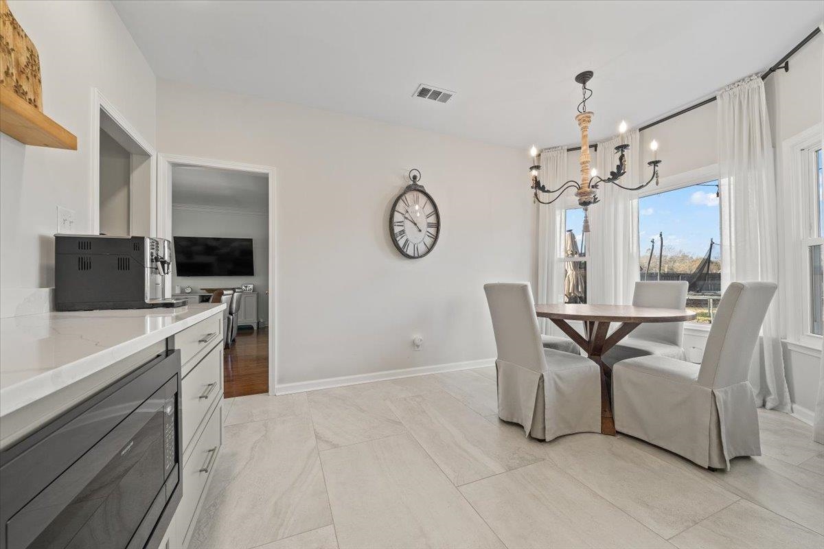 621 Fox Lair Cove Collierville, TN 38017 - Photo 19 of 37 a view of dining room and kitchen with furniture large window and wooden floor