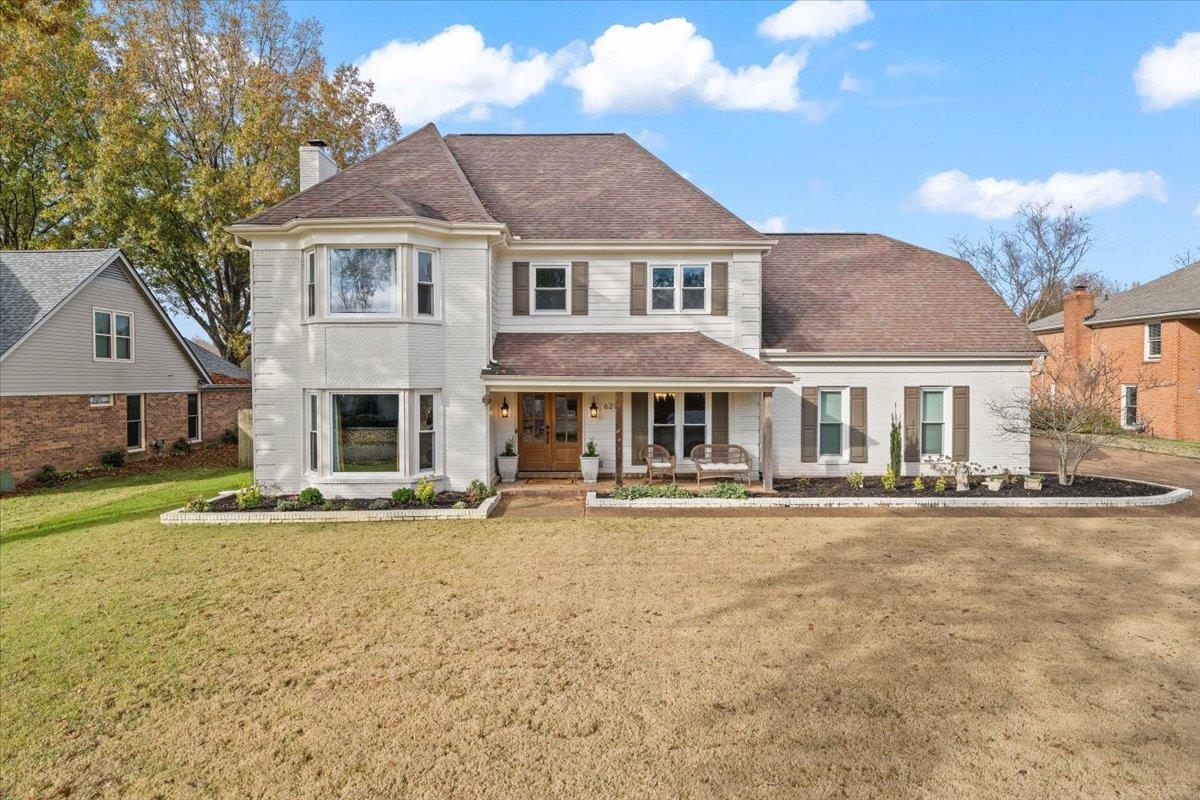 621 Fox Lair Cove Collierville, TN 38017 - Photo 2 of 37 View of front facade with covered porch, a chimney, brick siding, a front lawn, and a shingled roof