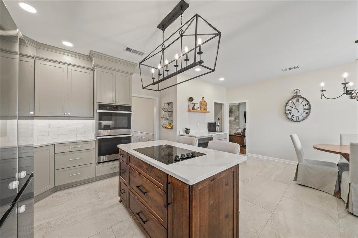 621 Fox Lair Cove Collierville, TN 38017 - Photo 23 of 37 Kitchen with a chandelier, a center island, stainless steel appliances, decorative light fixtures, and recessed lighting