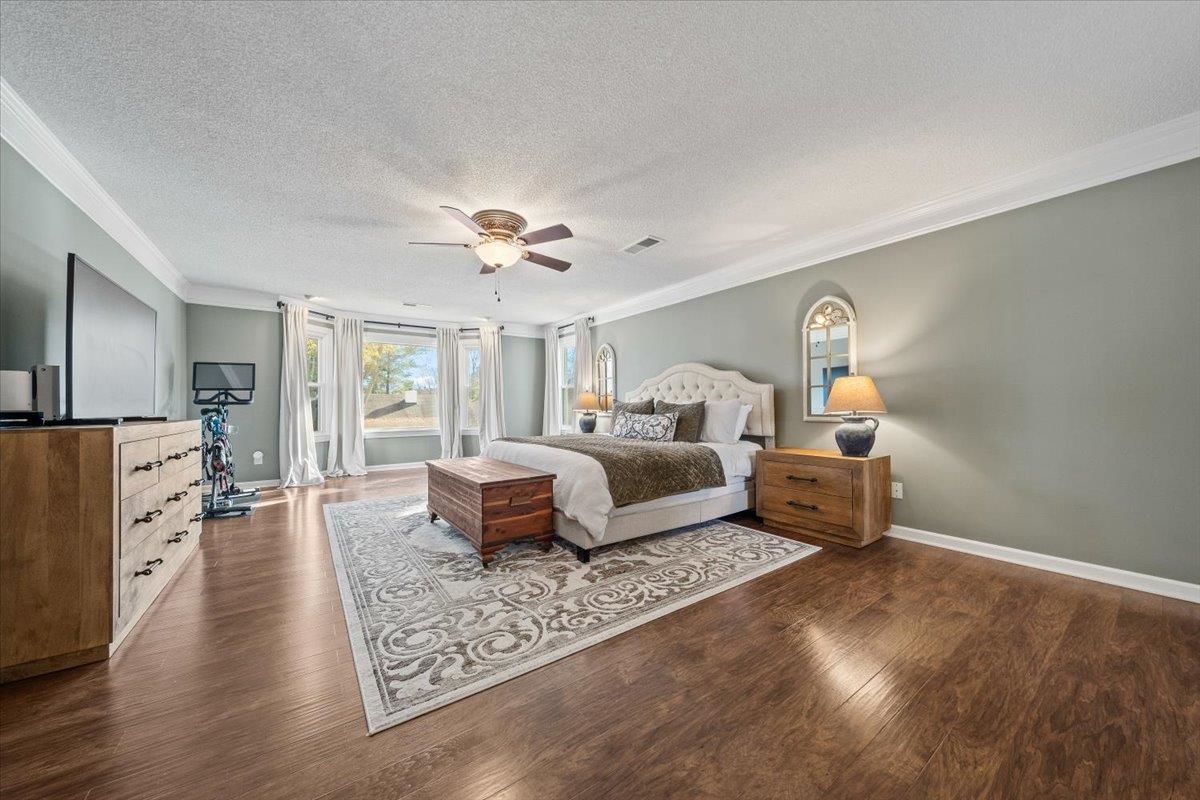 621 Fox Lair Cove Collierville, TN 38017 - Photo 27 of 37 Bedroom with crown molding, a textured ceiling, dark wood-style floors, and ceiling fan