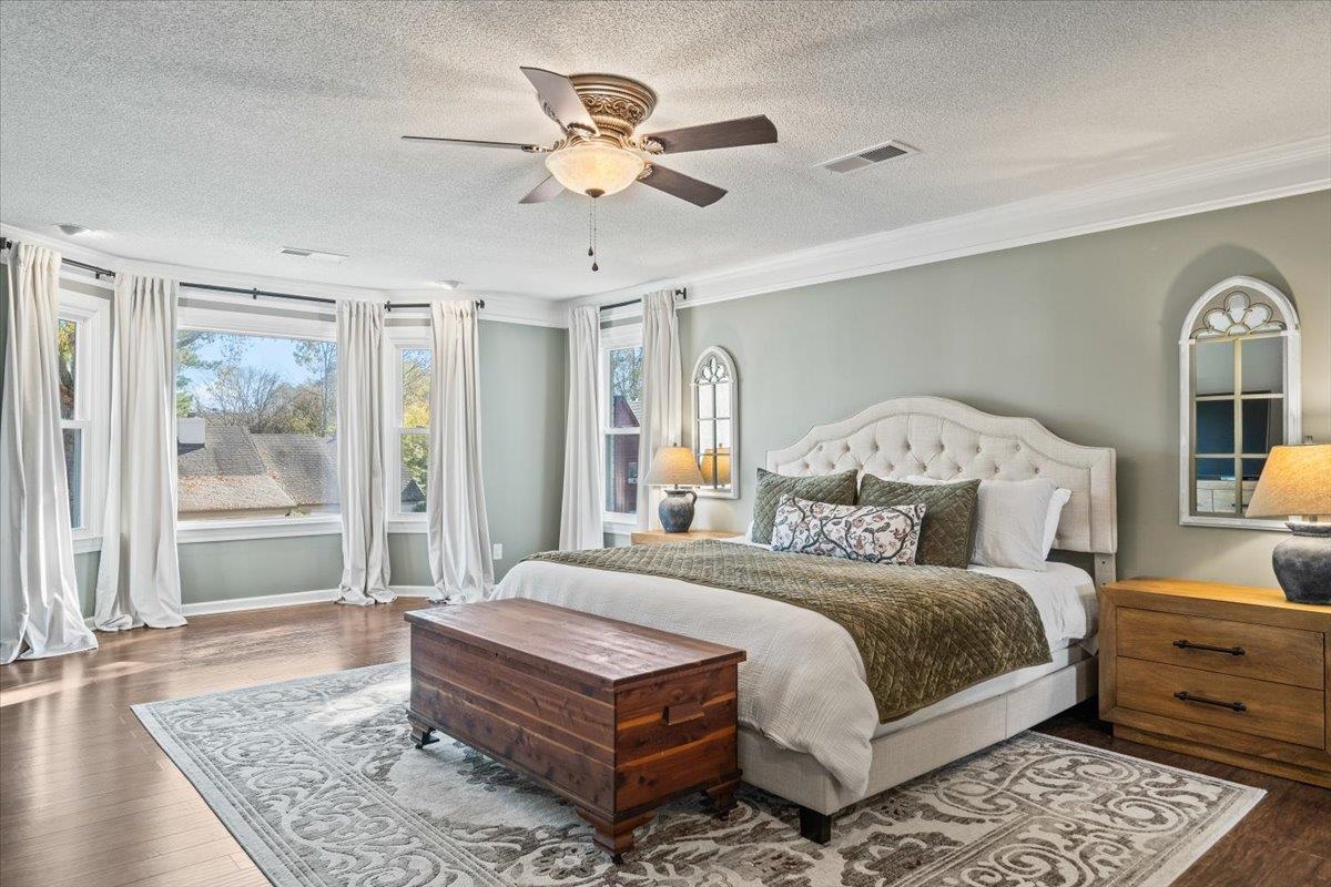 621 Fox Lair Cove Collierville, TN 38017 - Photo 28 of 37 Bedroom featuring dark wood-style flooring, a ceiling fan, crown molding, and a textured ceiling