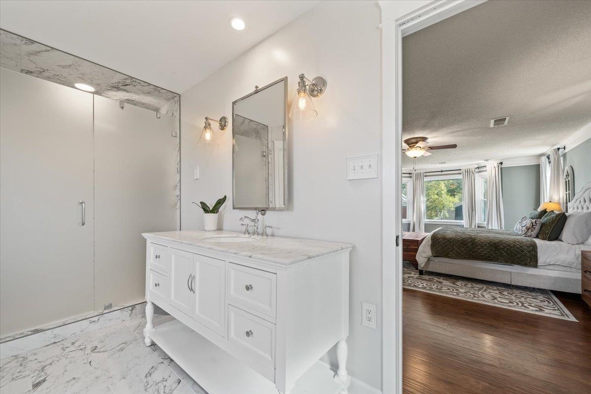621 Fox Lair Cove Collierville, TN 38017 - Photo 30 of 37 a en suite bathroom with a granite countertop sink and a mirror