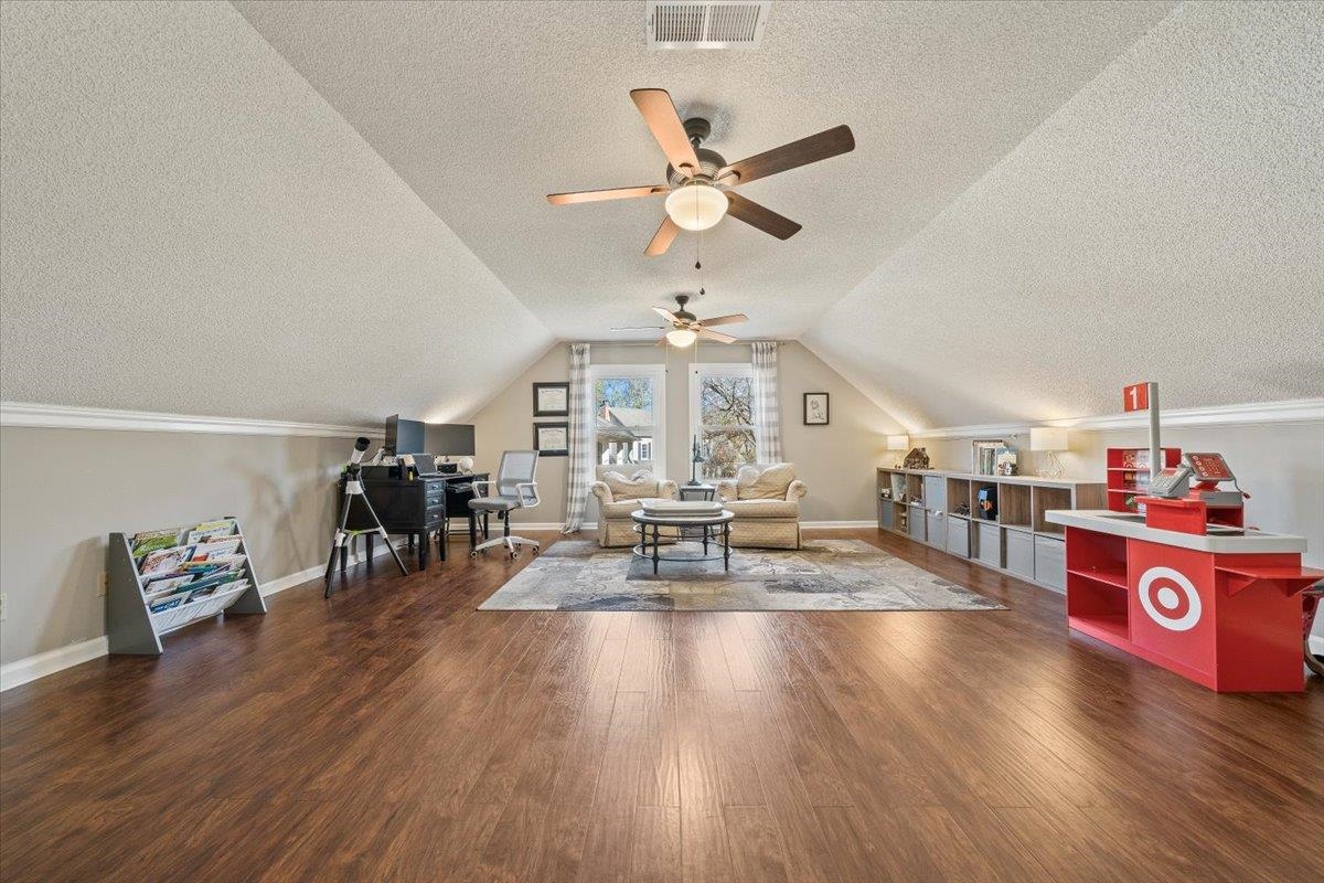 621 Fox Lair Cove Collierville, TN 38017 - Photo 32 of 37 Playroom featuring a textured ceiling, dark wood finished floors, vaulted ceiling, a desk, and ceiling fan