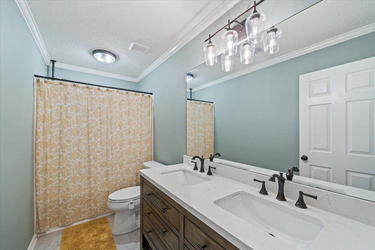 621 Fox Lair Cove Collierville, TN 38017 - Photo 34 of 37 a bathroom with a sink a toilet a mirror and shower curtain